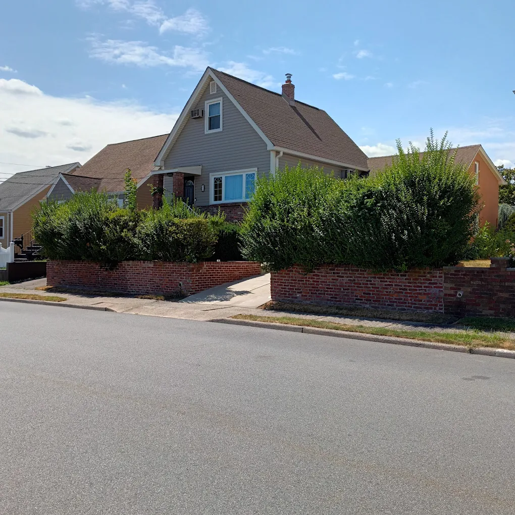 Well-kept Clifton NJ home with manicured hedges and lawn
